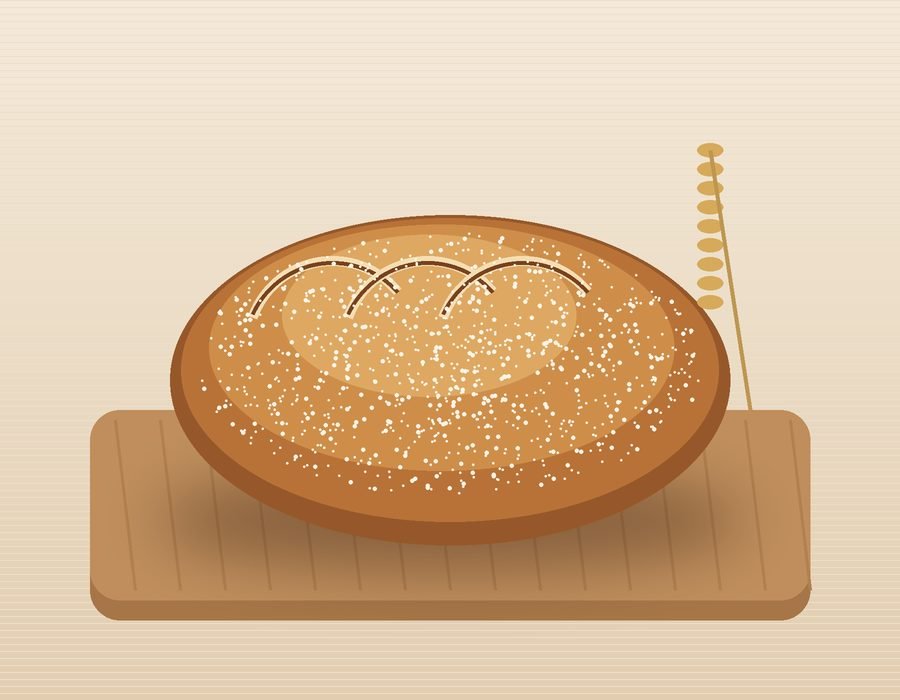 A scored sourdough loaf on a wooden board